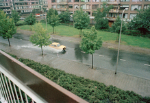 831075 Afbeelding van een auto die door de waterplassen heenrijdt in een ondergelopen Tigrisdreef te Utrecht.